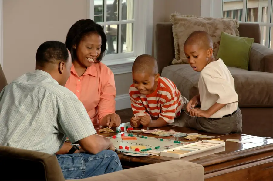 Parents laughing over a board game with their sons