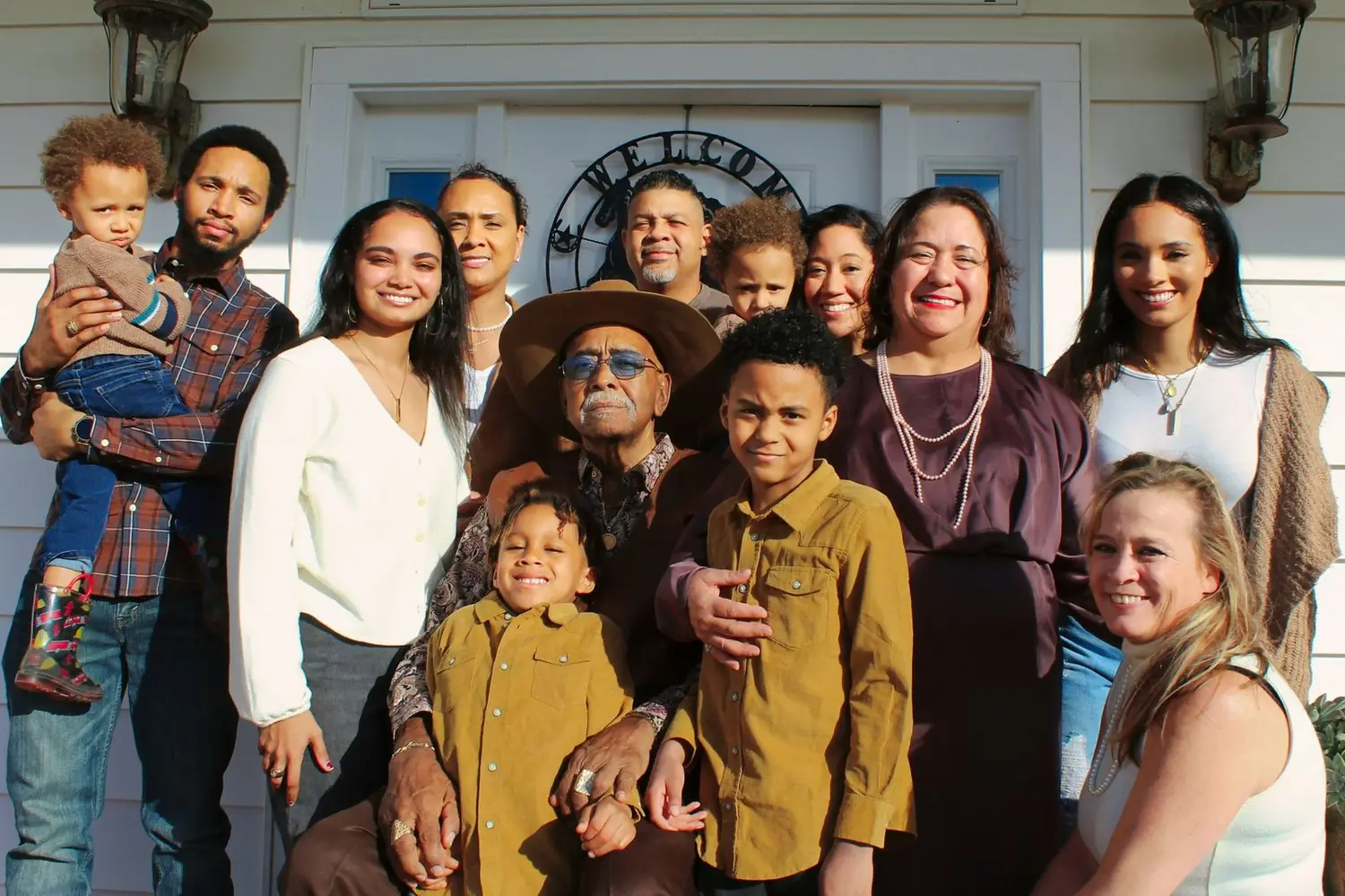 Four generations of one family smiling together on a porch
